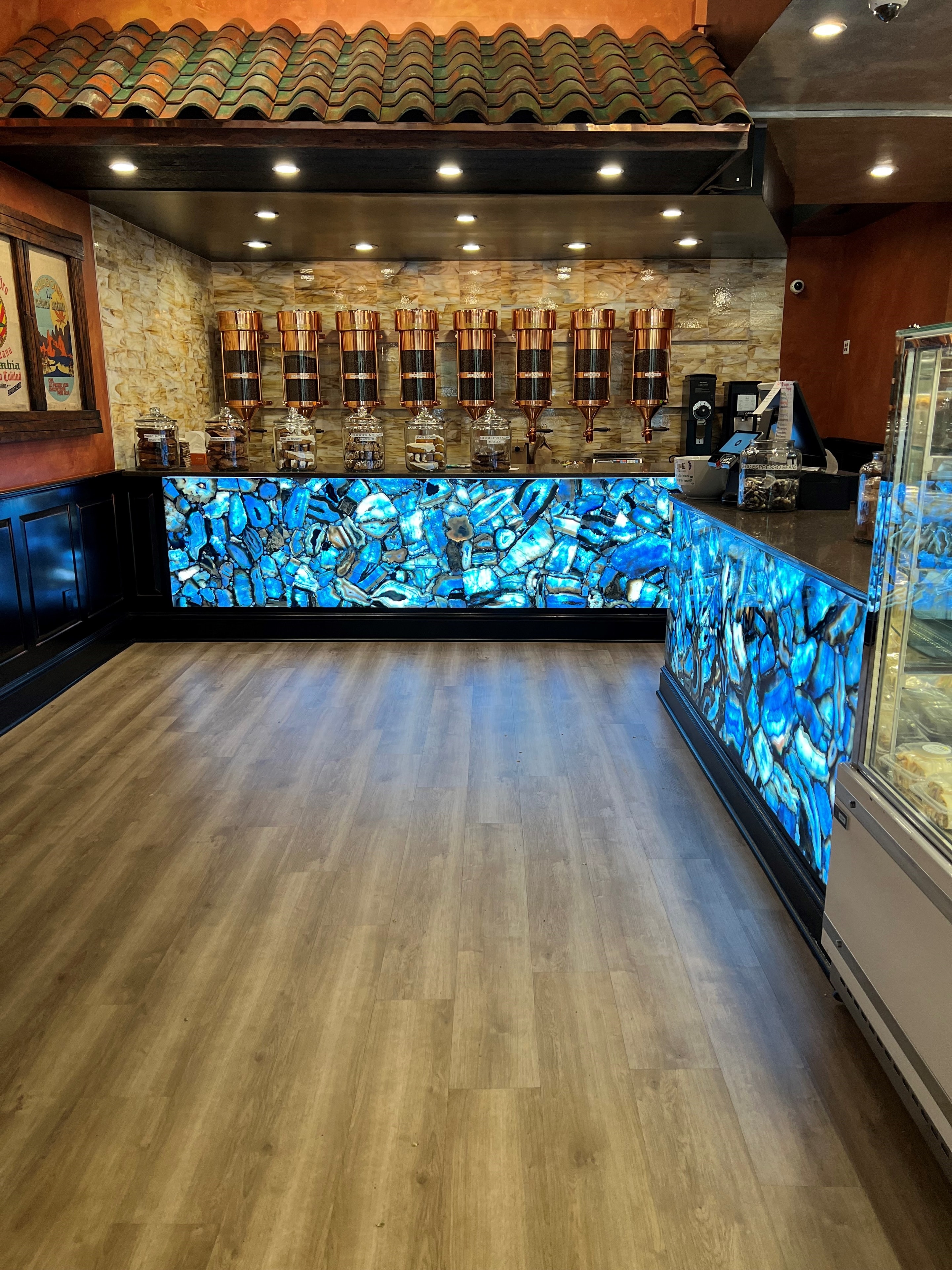 Backlit agate stone bar counter with recessed lighting and copper tap fixtures