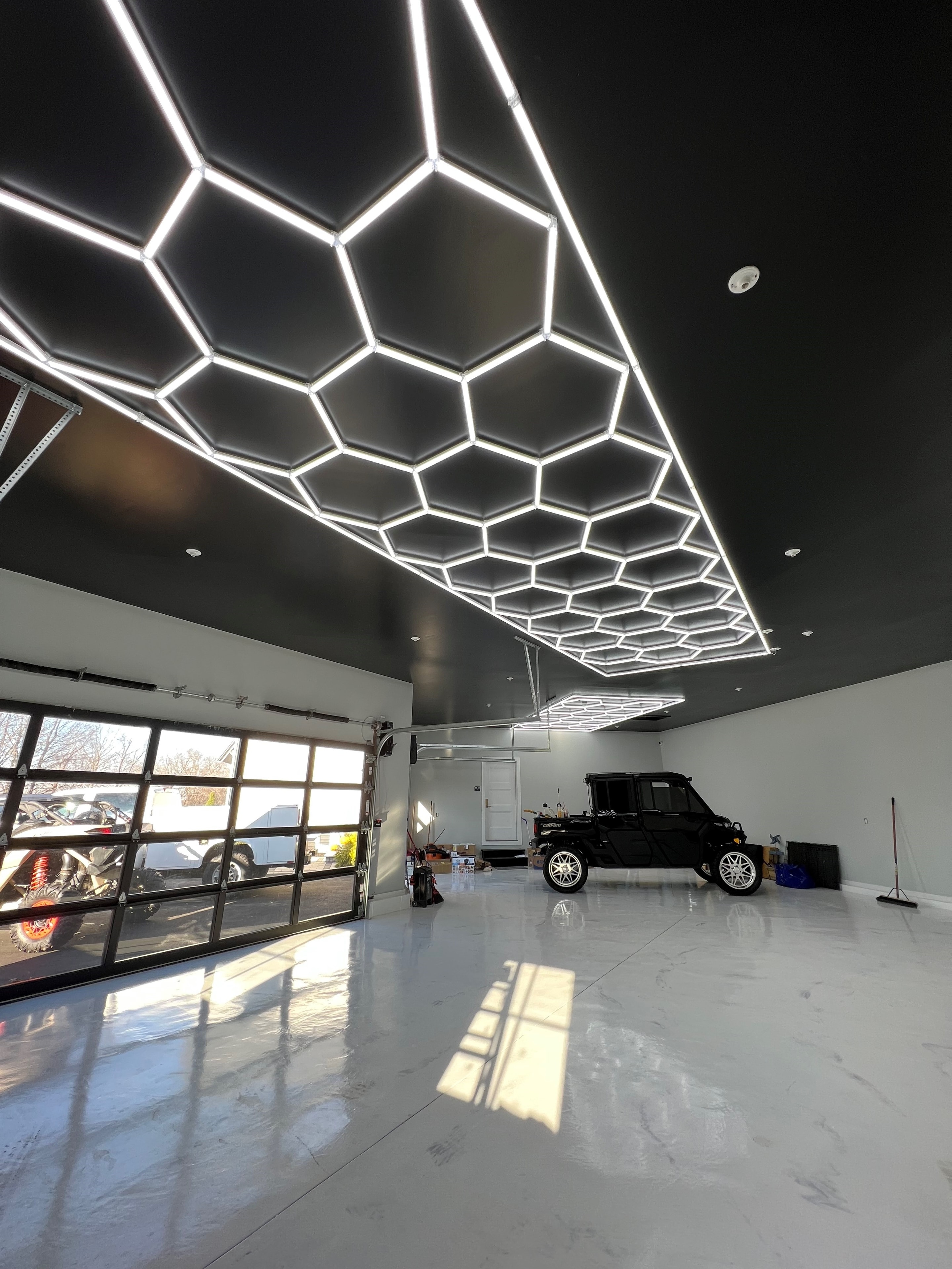 Custom hexagonal LED ceiling grid installation in a luxury residential garage