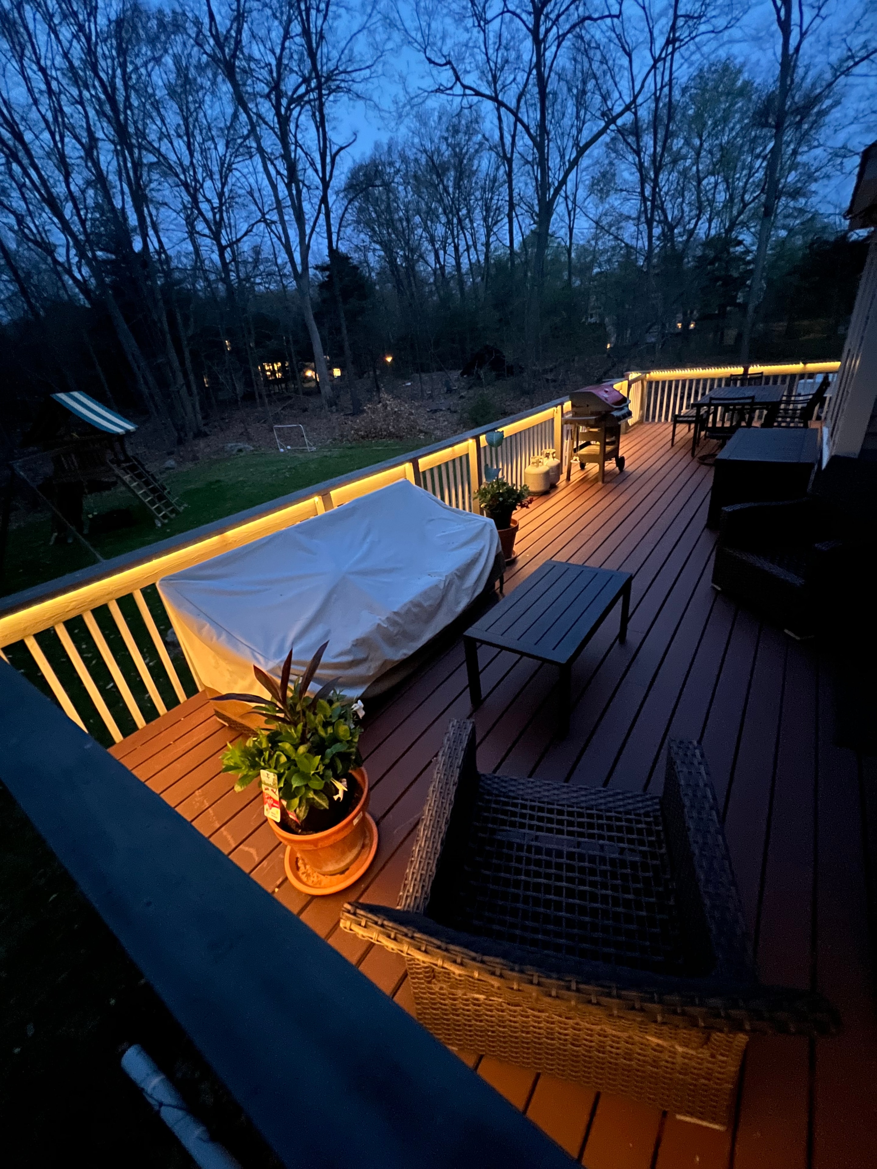 Warm LED perimeter lighting along a residential deck with outdoor seating