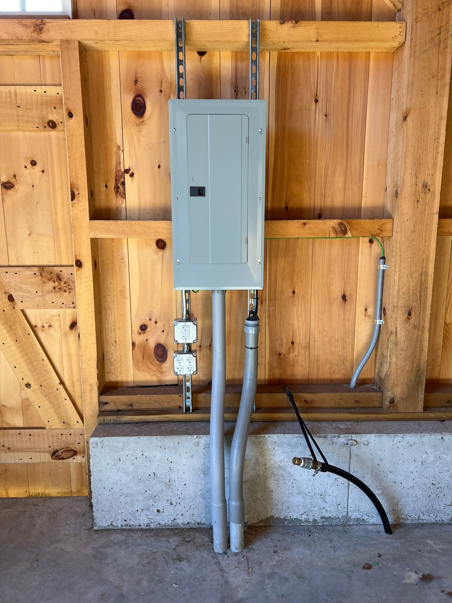 Sub-panel installation in a barn outbuilding with conduit and outlet rough-in