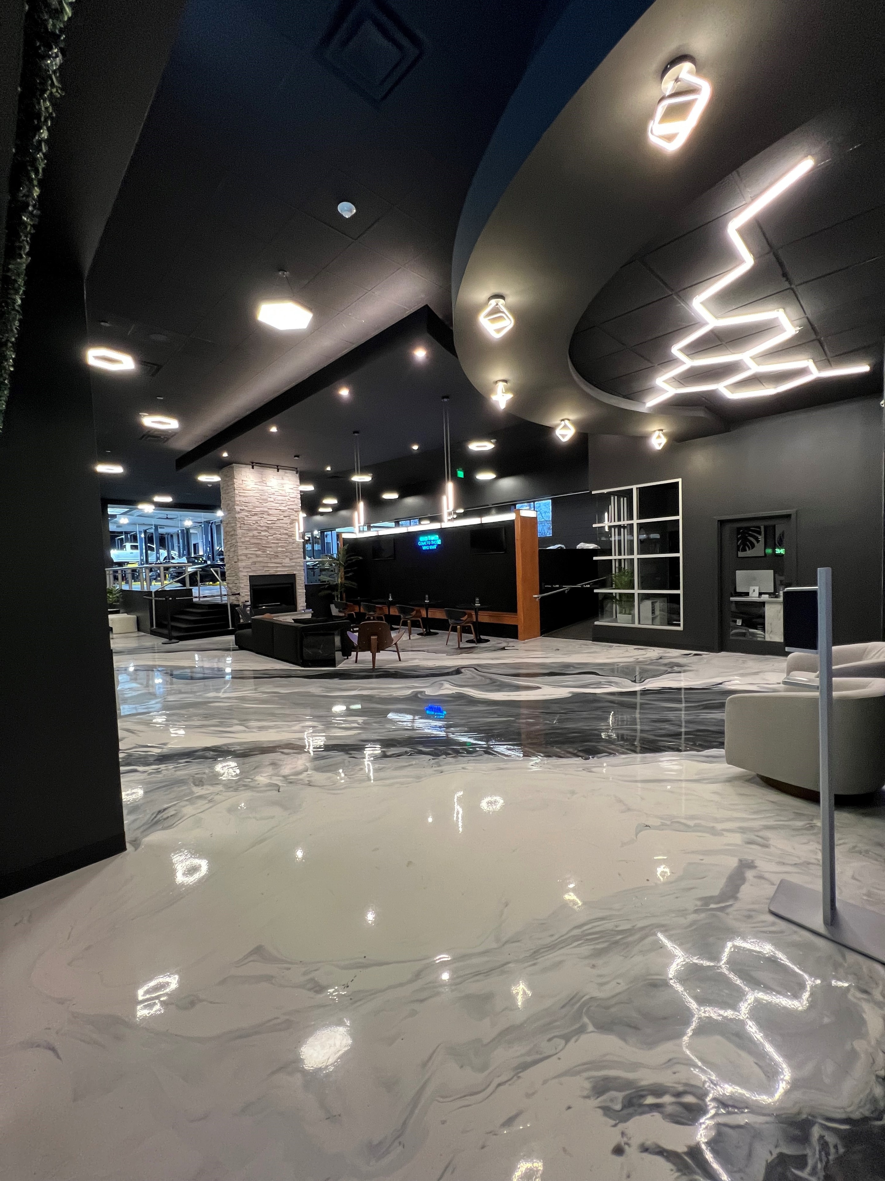 Marble epoxy floors with geometric LED ceiling fixtures in a luxury commercial space