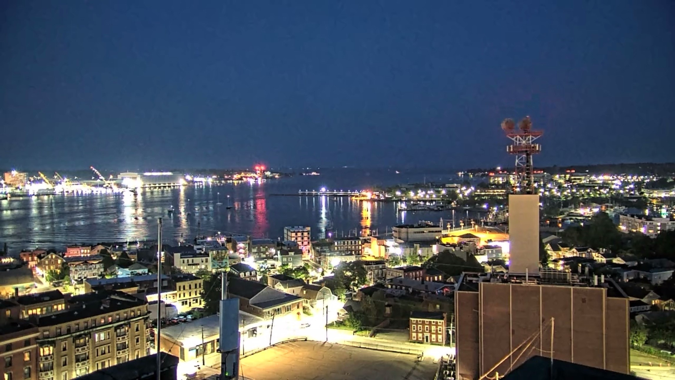 Nighttime harbor cityscape captured live by a rooftop PTZ security camera