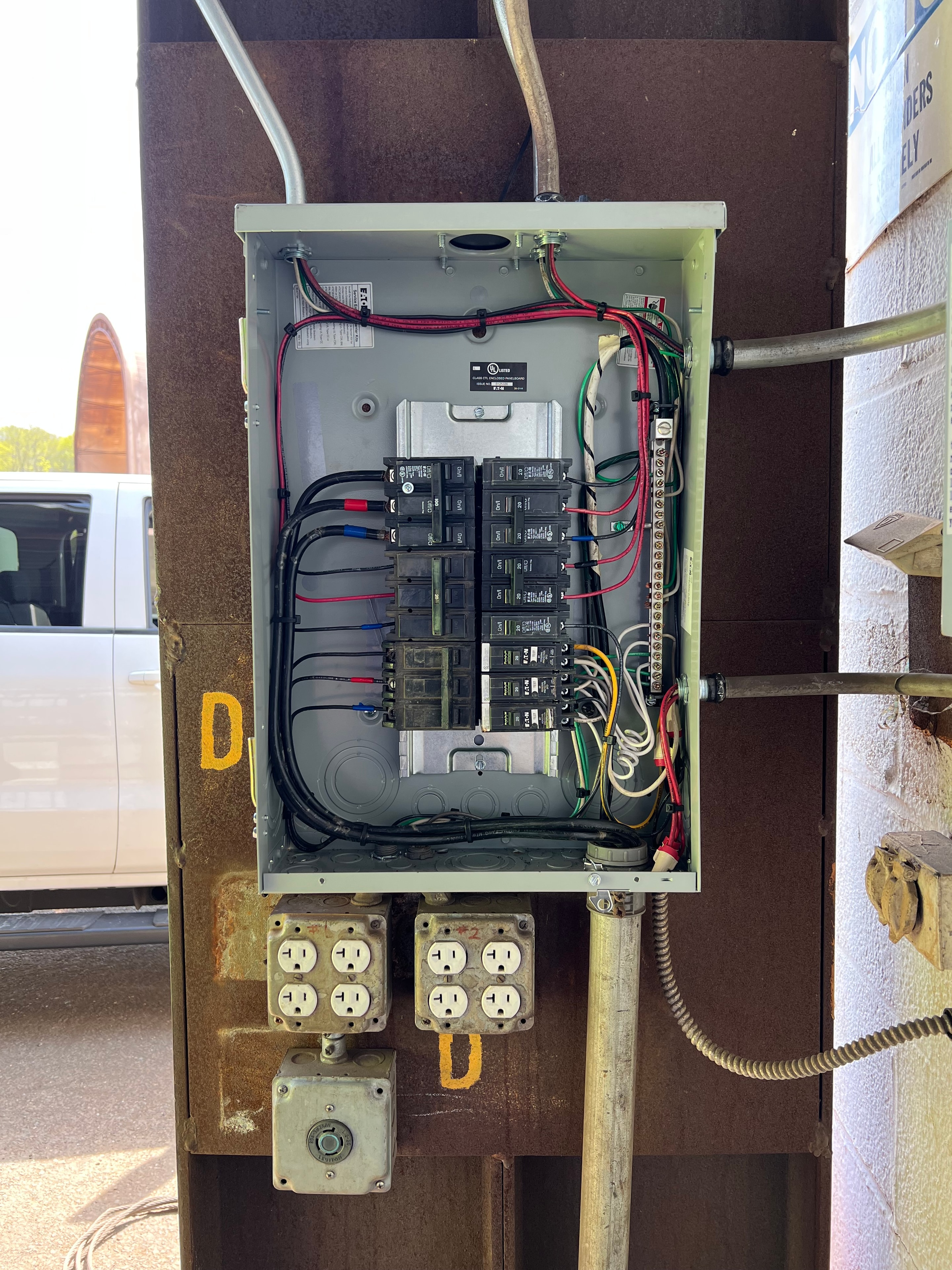 Eaton outdoor sub-panel with breakers and outlet boxes mounted to structural steel beam